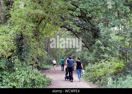 People walking and jogging along the Parkland Walk,  a disused railway line now an urban nature reserve, London Borough of Haringey Stock Photo