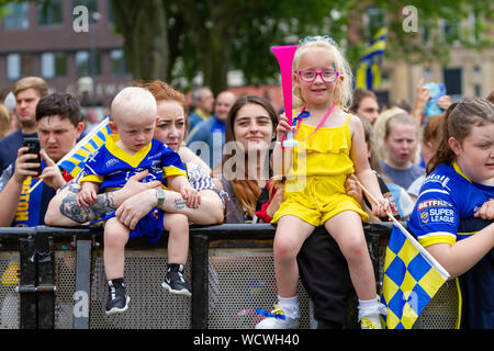 Warrington Wolves bring the Coral Challlenge Cup back home-girl with a horn sits on the fencing Stock Photo