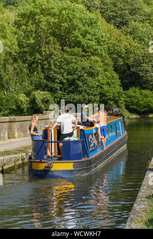 BATH, ENGLAND - JULY 2019: Narrow boat with people on board sailing over the Dundas Aquaduct on the Kennet & Avon Canal near the city of Bath Stock Photo