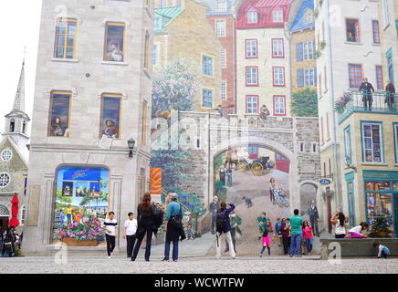 Travelers admiring mural building in Quebec City, Canada Stock Photo