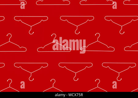 Fashion clothes hanger pattern on red background. Stock Photo