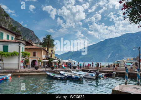 Boats in the old harbour of Limone sul Garda on Lake Garda underneath a blue sky. Stock Photo