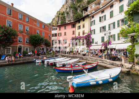 Limone sul Garda old harbour on Lake Garda.  In the centre of Limone is the old harbour filled with traditional Lake Garda boats and lined with cafes. Stock Photo