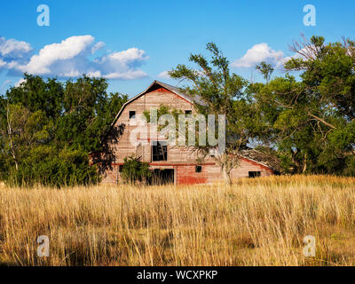 Old Kansas country Barn with green grass and blue sky with white clouds ...