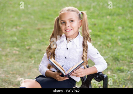 Secondary school student. Study language. Cute smiling small child hold book. Adorable little girl school student. School education concept. Cute little bookworm. Knowledge day. Ready for lessons. Stock Photo