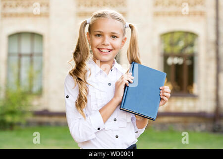 Ready for lessons. Secondary school student. Cute smiling small child hold book. Adorable little girl school student. Study language. School education concept. Cute little bookworm. Knowledge day. Stock Photo