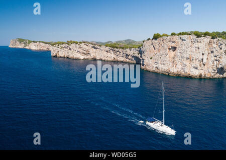 Yacht sailing on the Adriatic sea, cliffs of National park Telascica in background, Croatia Stock Photo