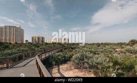 Smyrna Dunes Park.  A walkway over preserved sand dunes. Minorca condos in the background. Stock Photo