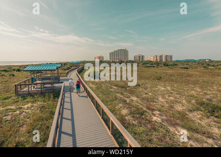 Senior walkers fit and active walking on the Smyrna Dunes boardwalk at New Smyrna Beach. Stock Photo