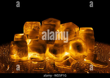 Melting frozen ice cubes illuminated with blue coloured LED light in the  dark Stock Photo - Alamy