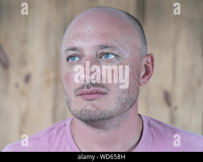 Closeup shoot of middle-aged caucasian bald man. People and lifestyle concept. Portrait of middle aged man indoors Stock Photo