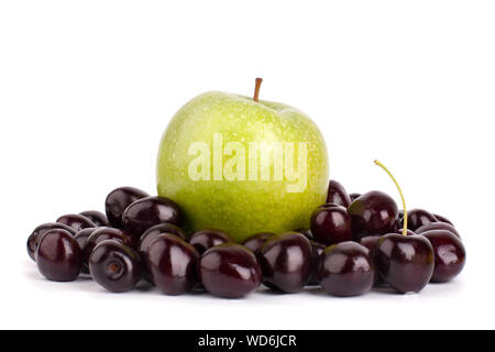 One whole green apple and many red ripe cherry berries on a white background isolated close up macro Stock Photo