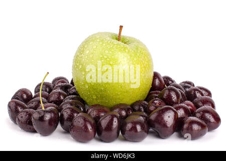 One whole green apple and many red ripe cherry berries on a white background isolated close up macro Stock Photo