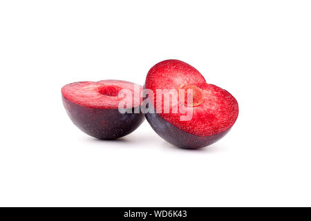 Two halves of a plum in the form of hearts red inside with a stone on a white background isolated close up Stock Photo