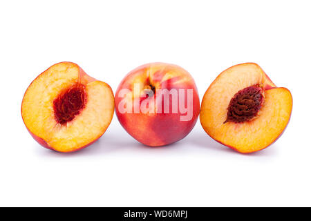 One peach and two halves of a peach with a stone on a white background isolated close up Stock Photo