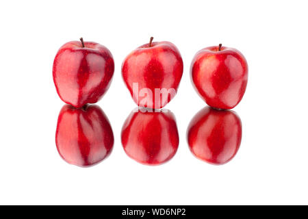 Three red apples on a white mirror background with reflection isolated close up Stock Photo