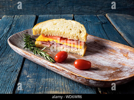 High Angle View Of Ham Sandwich With Tomatoes And Rosemary In Tray