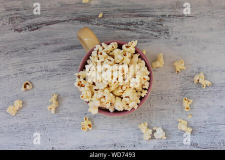 A bowl of delicious caramel popcorn on a white wooden background Stock Photo