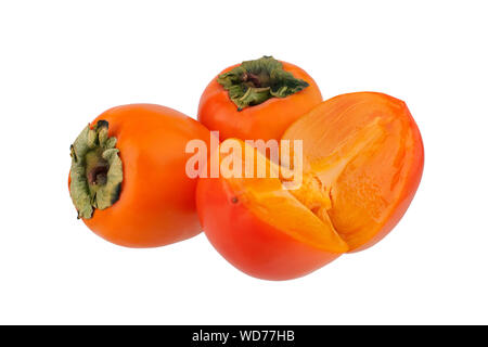 Two whole orange persimmons fruits or diospyros kaki and one persimmon sliced in half with green leaves on white background isolated close up Stock Photo