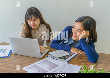Two happy ladies sharing joke during break time at office Stock Photo
