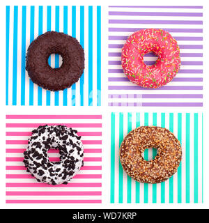 Different donuts on a multi-colored striped background top view Stock Photo