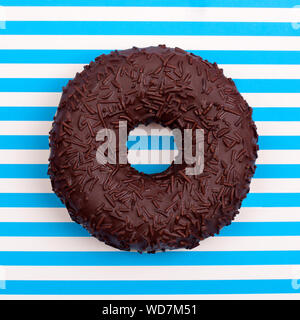 Donut in chocolate on a background in  white and blue strips top view in a square Stock Photo
