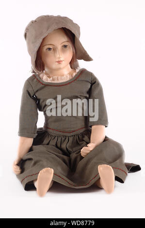 Antique Porcelain Doll with traditional clothes on and a bonnet. Stock Photo