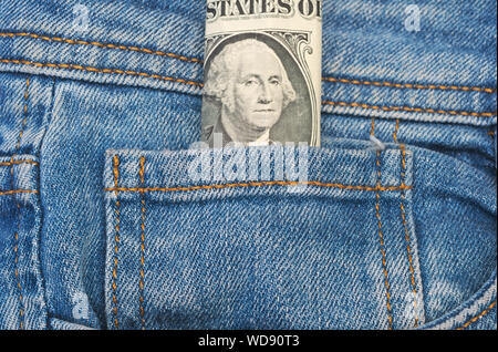 folded one dollar bill sticking out of a jeans front pocket Stock Photo