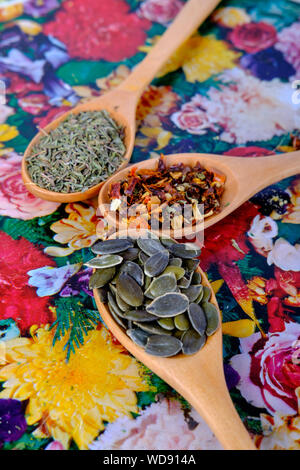 Wooden spoons with spices in on a flowery background Stock Photo