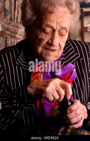 Senior citizen female opening her medication bottle with her hands Stock Photo