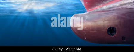 Big cargo ship sailing in the sea to International Shipping container terminal. Close up image detail ships bow, underwater view. Shipping business an Stock Photo