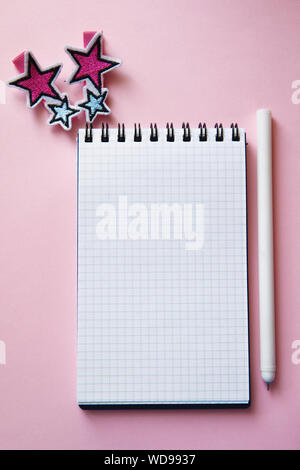 Blank notebook, pen and two hairpins on a two color background. Trendy pink and blue colors. Back to school concept. Mock up, flat lay, vertical. Stock Photo