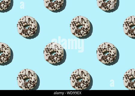 White and chocolate donut pattern on blue pastel background. Creative layout. Stock Photo