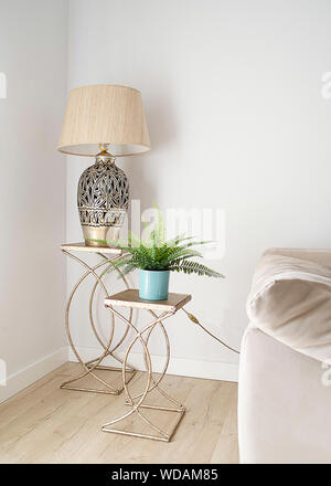 Elegant living room corner with a lamp and an artificial plant in two decorative tables. Bright minimalist decor. Interior design.  Inspirational livi Stock Photo