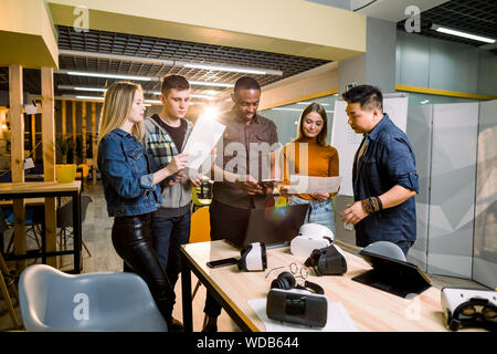 Young people software programmers testing a new apps with 3d virtual reality glasses, laptops and tablets in office Stock Photo
