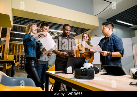 Young people software programmers testing a new apps with 3d virtual reality glasses, laptops and tablets in office Stock Photo