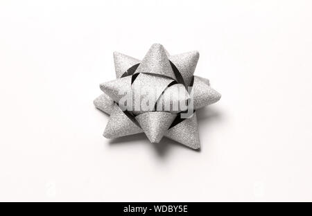 Silver glitter gift bow isolated on white. Stock Photo