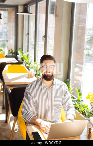 Nice handsome man working remotely on the laptop Stock Photo