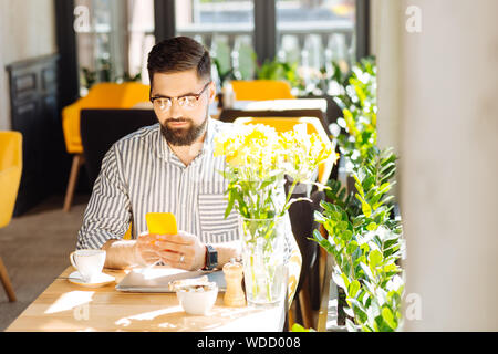 Nice good looking man using his modern smartphone Stock Photo