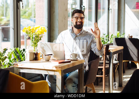 Delighted nice man calling for a waiter Stock Photo