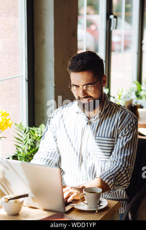 Delighted positive man looking at the keyboard Stock Photo