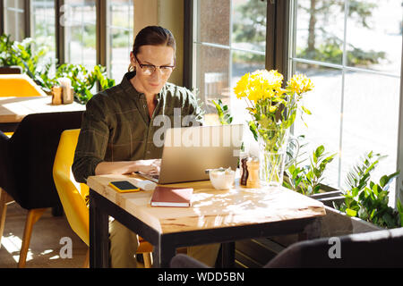 Handsome long haired man focusing on his work Stock Photo