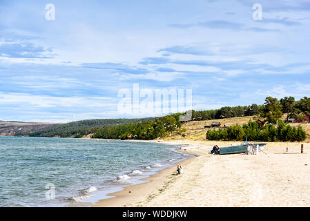Coast of Lake Baikal on the island of Olkhon. Landscape with boat and seagulls Stock Photo
