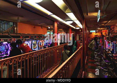 People play pachinko game inside Taito arcade store. Stock Photo