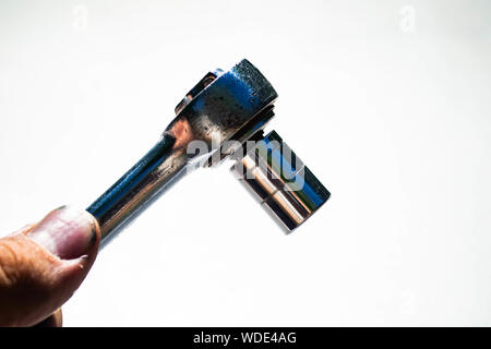 a mechanic holding a chrome socket wrench on a white background Stock Photo