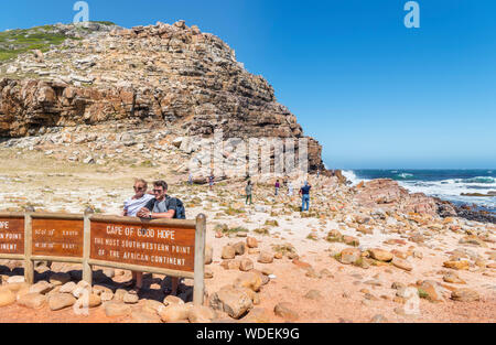 Couple posing for a photo by the sign at the Cape of Good Hope, the most south western point on the African continent, Western Cape, South Africa Stock Photo
