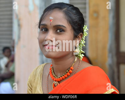 Beautiful young Malaysian Indian woman with flowers in her hair poses for the camera during Thaipusam. Stock Photo