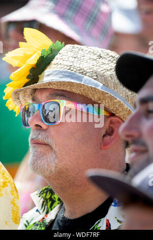 A man in a straw hat and wearing gay pride sunglasses at the Other Stage at the Glastonbury Festival 2019 in Pilton, Somerset Stock Photo