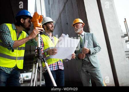 Engineer, foreman and worker discussing in building construction site Stock Photo