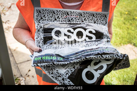 A woman delivering a package from asos, the online fashion clothing website Stock Photo